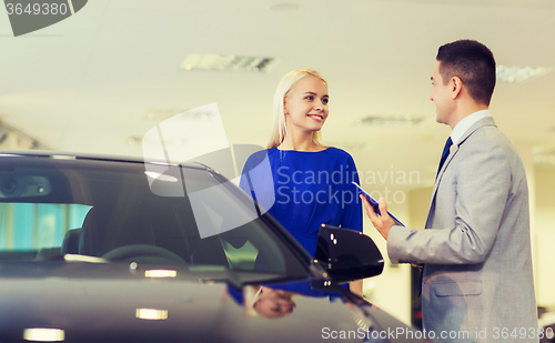 Image of happy woman with car dealer in auto show or salon