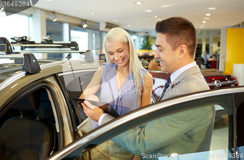 Image of happy woman with car dealer in auto show or salon