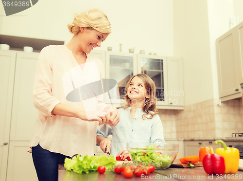 Image of happy family making dinner in kitchen