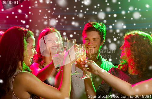 Image of smiling friends with glasses of champagne in club