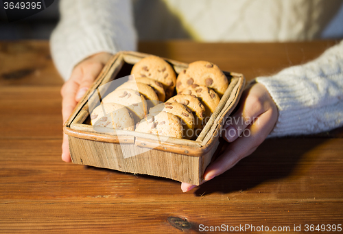 Image of close up of woman with oat cookies at home