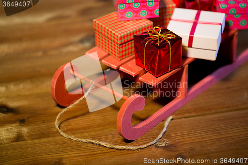 Image of close up of christmas gift boxes on wooden sleigh