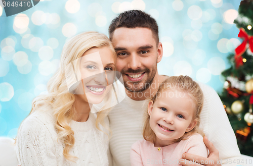 Image of happy family at home with christmas tree