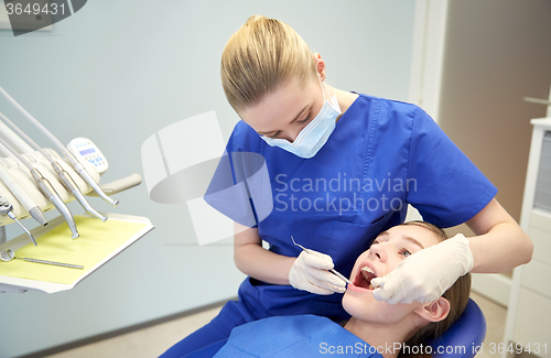 Image of female dentist checking patient girl teeth