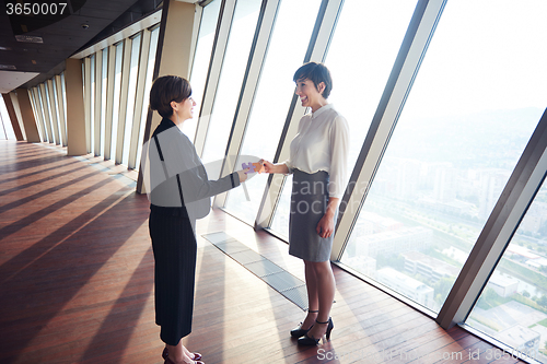 Image of business woman group assembling jigsaw puzzle