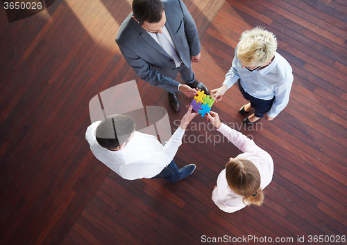 Image of business people group assembling jigsaw puzzle