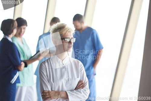 Image of female doctor with glasses and blonde hairstyle standing in fron