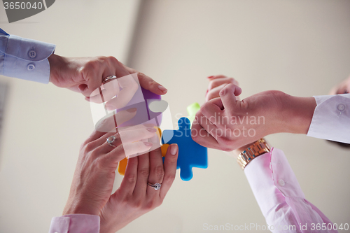 Image of business people group assembling jigsaw puzzle