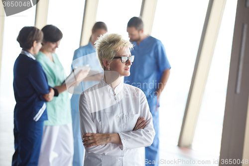 Image of female doctor with glasses and blonde hairstyle standing in fron