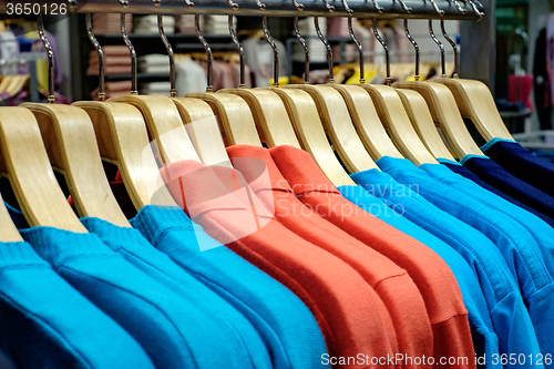 Image of Clothing on hangers in shop