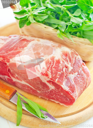 Image of raw meat and knife on the wooden board