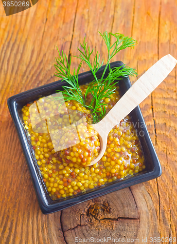 Image of Mustard in the black bowl on table