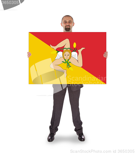 Image of Smiling businessman holding a big card, flag of Sicily