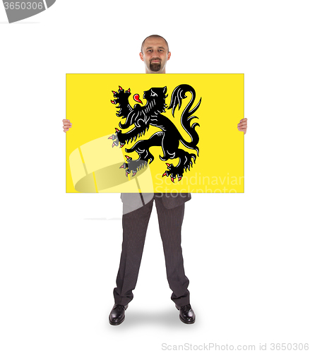 Image of Smiling businessman holding a big card, flag of Flanders