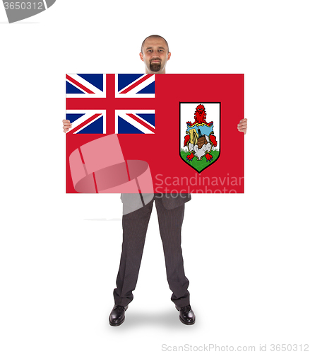 Image of Smiling businessman holding a big card, flag of Bermuda