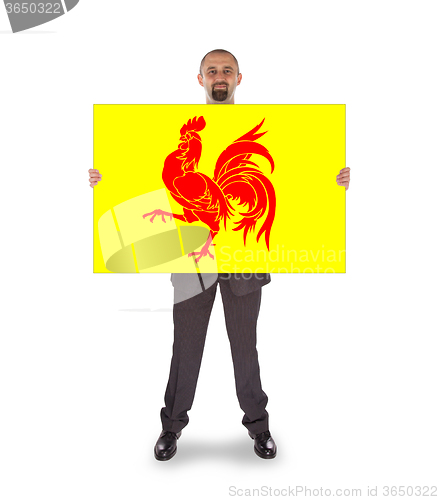 Image of Smiling businessman holding a big card, flag of Wallonia
