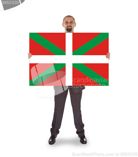 Image of Smiling businessman holding a big card, flag of Basque Country