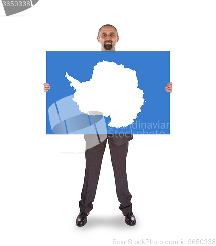 Image of Smiling businessman holding a big card, flag of Antarctica