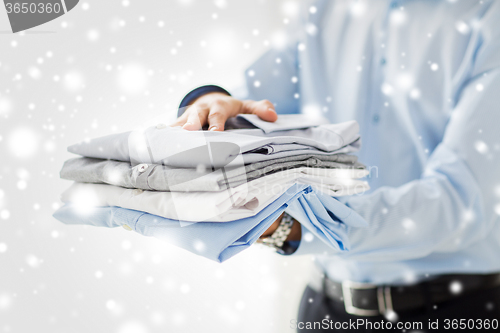 Image of close up of businessman holding folded shirts