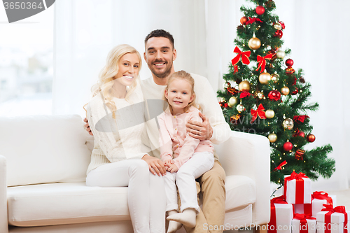 Image of happy family at home with christmas tree