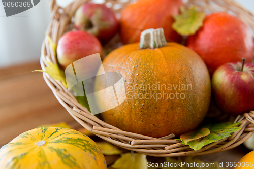 Image of close up of pumpkins in basket on wooden table