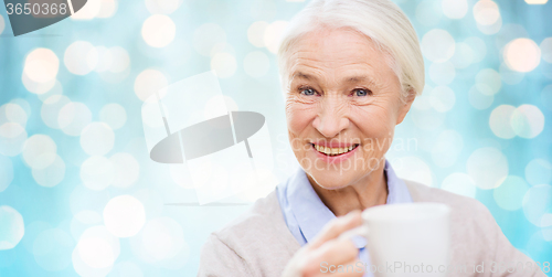 Image of happy senior woman with cup of tea or coffee