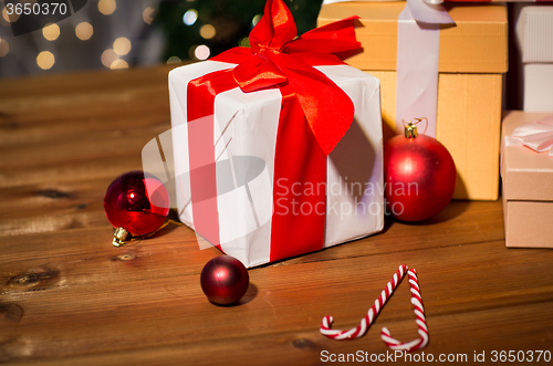 Image of gifts, candies and christmas balls on wooden board