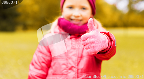 Image of happy girl showing thumbs up outdoors