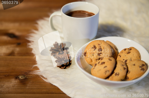 Image of cups of hot chocolate with cookies on fur rug