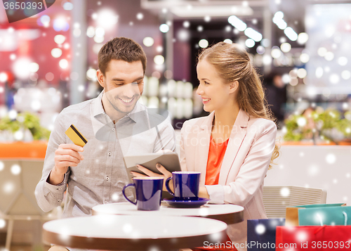 Image of couple with tablet pc and credit card in mall