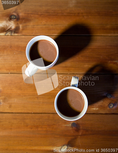 Image of cups of hot chocolate or cocoa drinks on wood