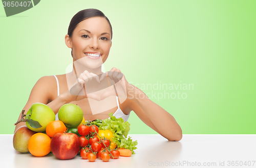 Image of woman with healthy food showing heart shape sign
