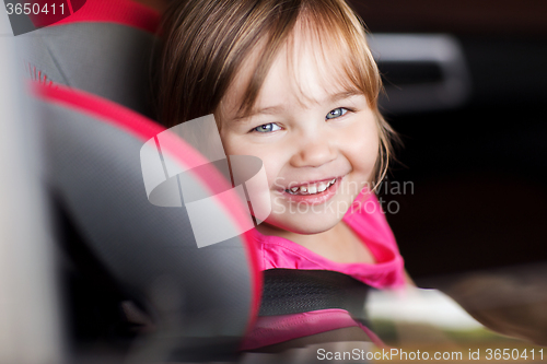 Image of happy little girl sitting in baby car seat