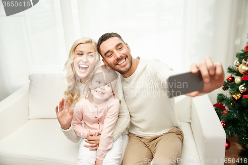 Image of family taking selfie with smartphone at christmas