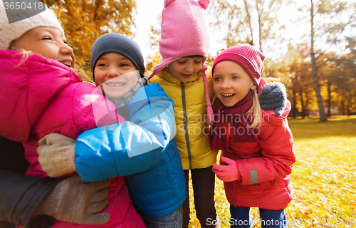 Image of group of happy children hugging in autumn park