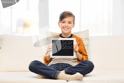 Image of smiling boy with tablet computer at home