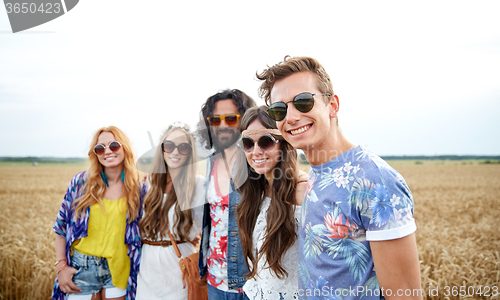 Image of smiling young hippie friends on cereal field