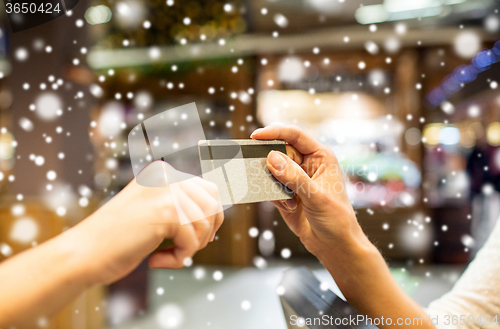 Image of close up of hands giving credit card in mall