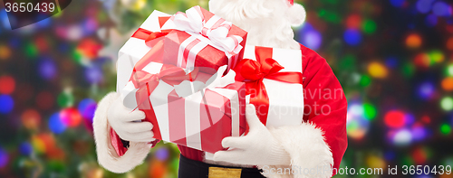 Image of man in costume of santa claus with gift boxes