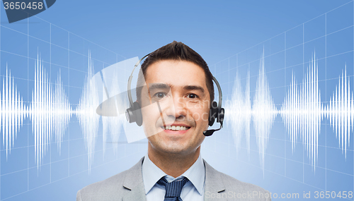 Image of businessman in headset over sound wave or diagram