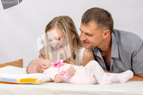 Image of Happy Mom and Dad look at his two-month baby