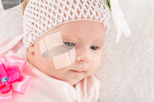 Image of Portrait of a two-year baby girl with a bandage on his head with a flower