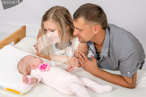 Image of Mom and Dad with a smile, looking at her two month baby