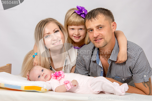 Image of Mother, father, daughter and five-year newborn baby looks in the picture