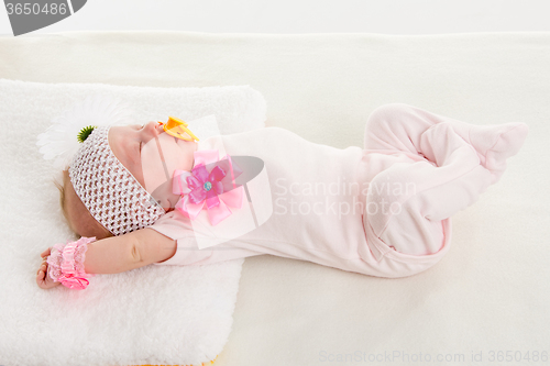 Image of Baby girl stretches in his sleep lying in bed