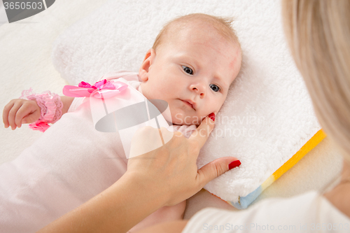 Image of Mom leaned her finger to her cheek two-month girl