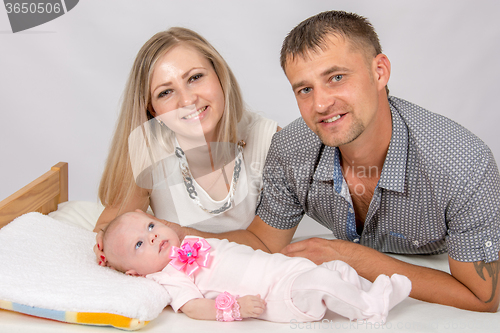 Image of Mom and dad looking at the frame is close to a two-month baby