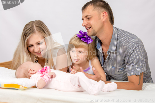 Image of Mother, father and daughter is considering a five-year new-born baby