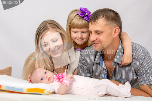 Image of Mother, father and daughter, five-year look at newborn baby