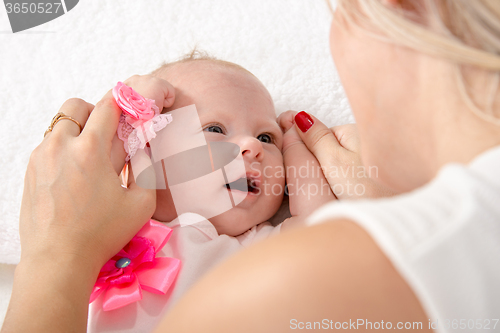 Image of Mom took the handles of the baby girl and put it to her head